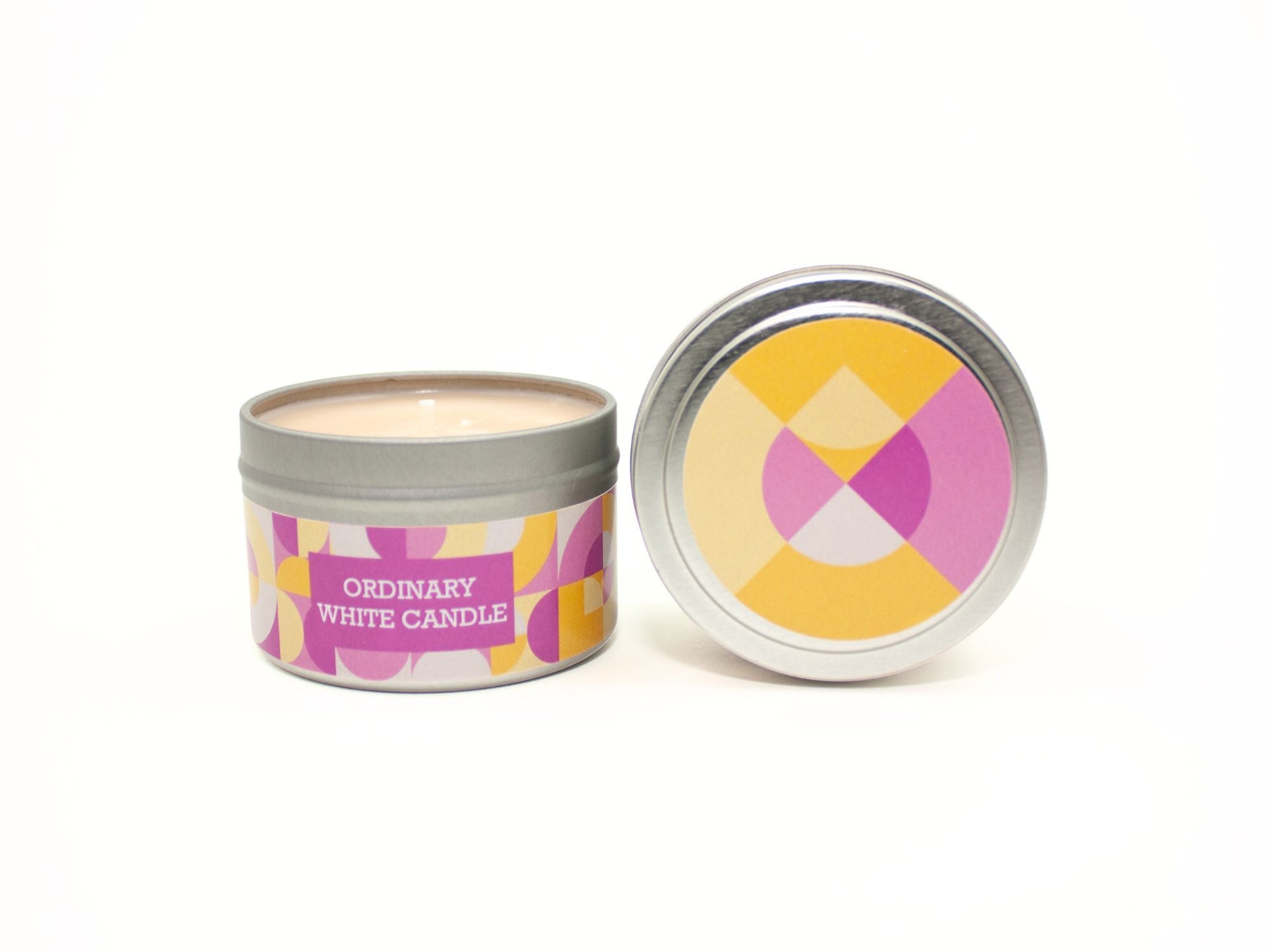 Onset & Rime flannel scented candle called "Ordinary White Candle" in a 4 oz silver tin. The circular label on top is a geometric pattern of pink, yellow and white circles and teardrops. The text on the front label is "Ordinary White Candle - Warm Flannel, Lemon Blossom, Sheer Musk".
