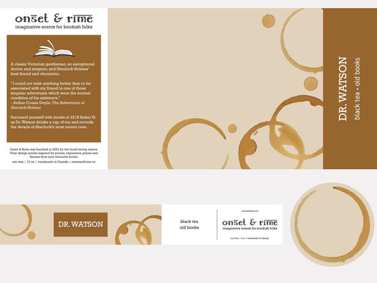A close up view of the label for the Onset & Rime tea and old books scented candle called "Dr. Watson". The label is the colour of aged paper with a few circular tea stains. The text on the label is "Dr. Watson - Black Tea, Old Books".